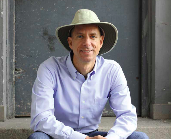 John Strelecky, amerikanischer Autor, sitzt auf einer Treppe