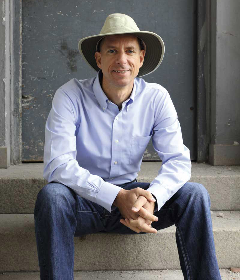 John Strelecky, amerikanischer Autor, sitzt auf einer Treppe